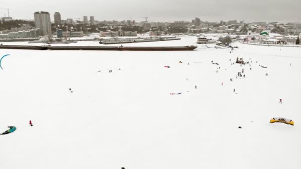 CHEBOKSARY, RUSIA - 31 DE DICIEMBRE DE 2018: Atletas involucrados en el snowkiting, en el paseo de invierno en el río con los disfraces de Santa Claus, fotografía aérea de un quadrocopter — Vídeo de stock