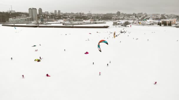 CHEBOKSARY, RÚSSIA - DEZEMBRO 31, 2018: Atletas envolvidos em snowkiting, no passeio de inverno no rio nos trajes do Papai Noel, fotografia aérea de um quadricóptero — Vídeo de Stock