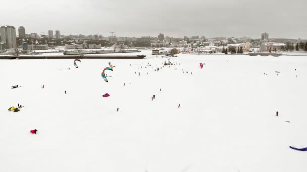 CHEBOKSARY, RUSIA - 31 DE DICIEMBRE DE 2018: Atletas involucrados en el snowkiting, en el paseo de invierno en el río con los disfraces de Santa Claus, fotografía aérea de un quadrocopter — Vídeo de stock