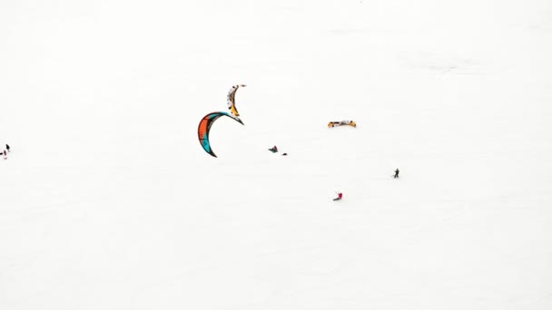 CHEBOKSARY, RUSIA - 31 DE DICIEMBRE DE 2018: Atletas involucrados en el snowkiting, en el paseo de invierno en el río con los disfraces de Santa Claus, fotografía aérea de un quadrocopter — Vídeos de Stock