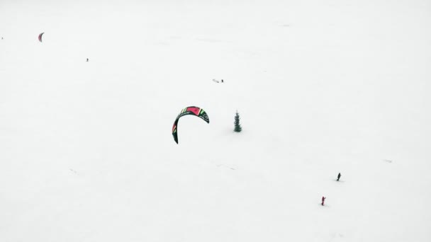 Snowkiting athletes ride on the river in Santa Claus costumes in winter — Stock Video