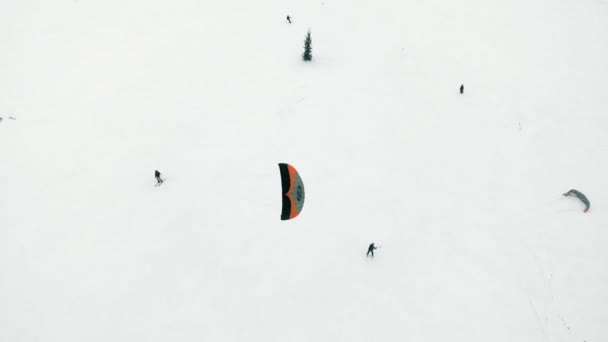 Snowkiting athletes ride on the river in Santa Claus costumes in winter — Stock Video