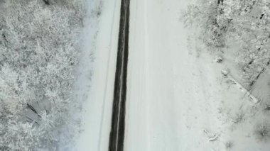 Kış ülkede yol karlı bir orman, drone ile havadan görünümü