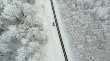 Kış ülkede yol karlı bir orman, drone ile havadan görünümü