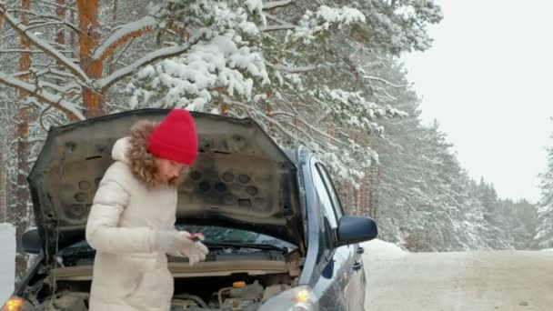 Vrouw met een stro auto op de weg in de winter — Stockvideo