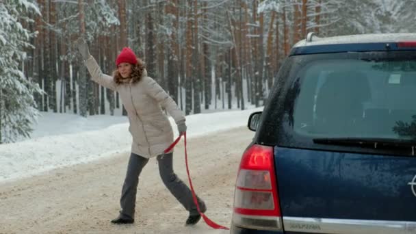 Kvinna med en halm bil på vägen i vinter — Stockvideo