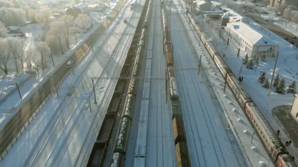 Kanasj, Rusland - 7 januari 2019: Vliegen over de railroad tracks met een locomotief en wagons. Winter. Luchtfoto, copter schieten — Stockvideo