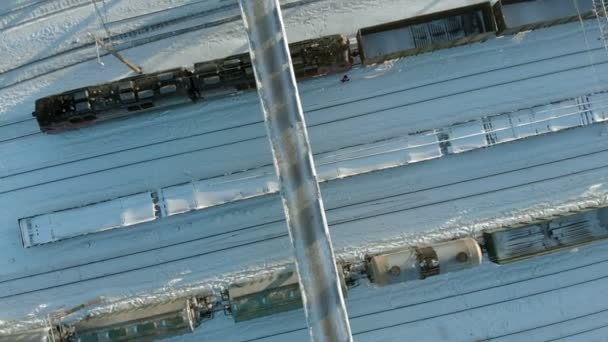 Kanasj, Rusland - 7 januari 2019: Vliegen over de railroad tracks met een locomotief en wagons. Winter. Luchtfoto, copter schieten — Stockvideo