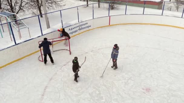 Cheboksary, Rusia - 5 de enero de 2019: niños patinan y juegan al hockey en la pista, el concepto de recreación deportiva, aéreo, rodaje de helicópteros — Vídeo de stock