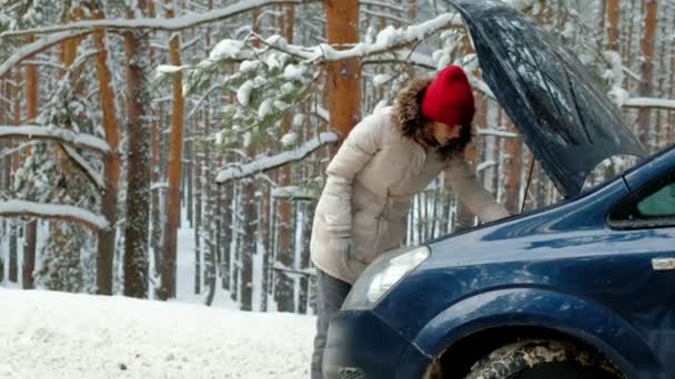 Жінка з солом'яним автомобілем на дорозі взимку — стокове відео