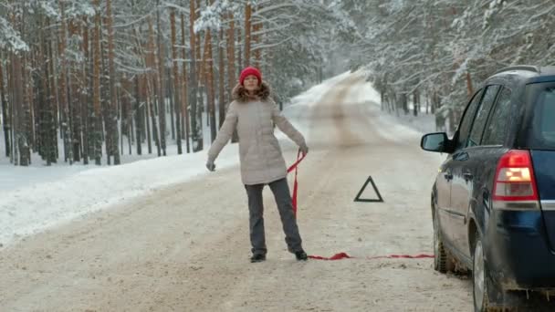 Mujer con un coche de paja en la carretera en invierno — Vídeo de stock