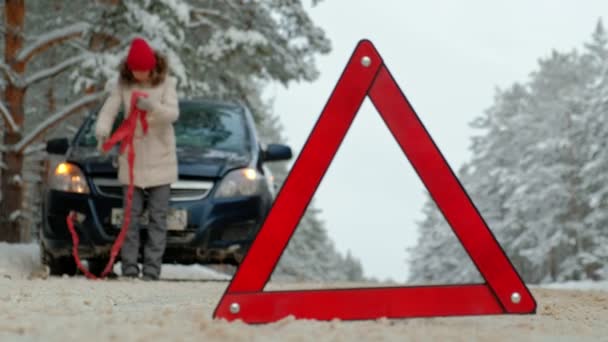 Vrouw met een stro auto op de weg in de winter — Stockvideo