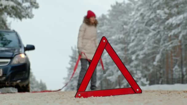 Γυναίκα με ένα άχυρο αυτοκίνητο στο δρόμο το χειμώνα — Αρχείο Βίντεο