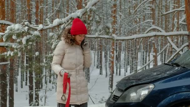 Жінка з солом'яним автомобілем на дорозі взимку — стокове відео