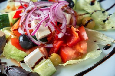 Taze sebzeli Yunan salatası, peynir ve siyah zeytin.