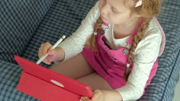 Маленькая девочка раскрашивает на планшете — стоковое видео