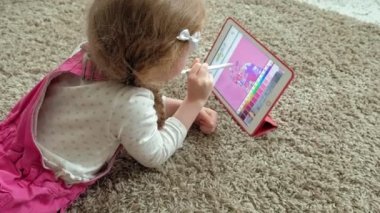 Küçük kız bir tablet üzerinde boyama