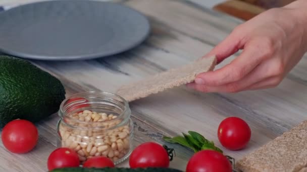 女人的手 涂抹一条奶酪的面包 健康的素食三明治 厨房的桌子与各种蔬菜和蔬菜 烹饪背景 — 图库视频影像
