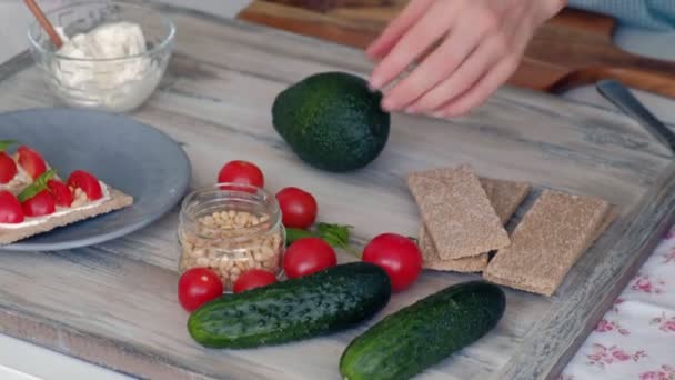 Female Hands Peels Avocado Healthy Vegetarian Sandwiches Kitchen Table Various — Stock Video