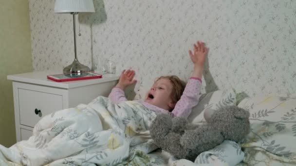 Niña en la cama jugando en la tableta — Vídeos de Stock