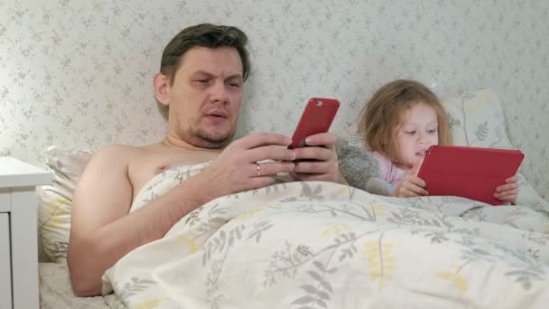 Tata i małą córeczkę na łóżku na tablecie — Wideo stockowe