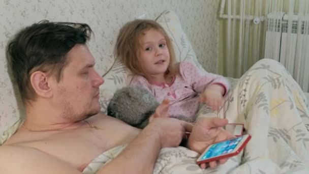 Ο μπαμπάς και η μικρή της κόρη για το κρεβάτι έπαιζαν στο tablet — Αρχείο Βίντεο