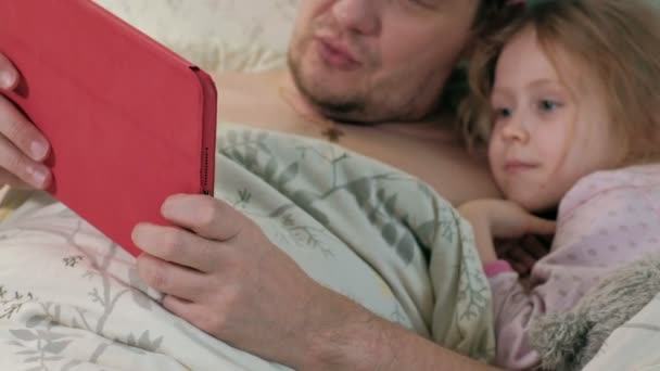 Pai e filha na cama brincando no tablet — Vídeo de Stock