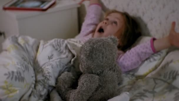 タブレットで遊んでベッドで小さな女の子 — ストック動画
