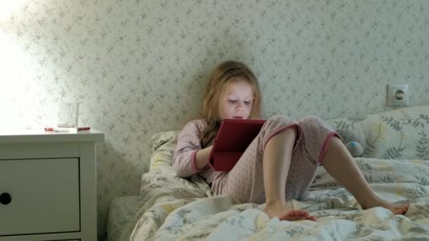 Klein meisje in bed spelen op Tablet PC — Stockvideo