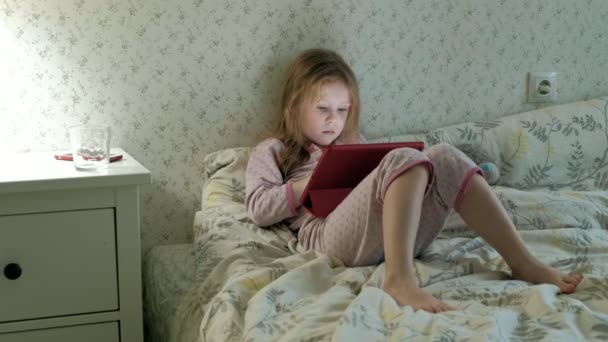 태블릿에 침대에 있는 어린 소녀 — 비디오