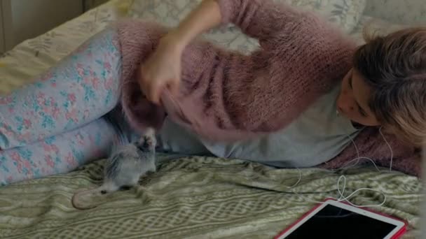 Mujer joven con una rata divertida en casa, jugando y alimentándola — Vídeo de stock