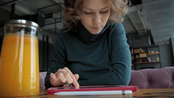 Aantrekkelijke jonge vrouw met tablet in café, freelancer concept — Stockvideo