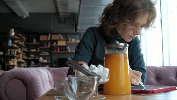 Atractiva joven con tableta en la cafetería, concepto freelancer — Vídeos de Stock