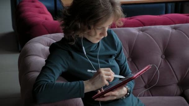Atraktivní mladá žena s tabletem v kavárně, na volné noze koncepce — Stock video