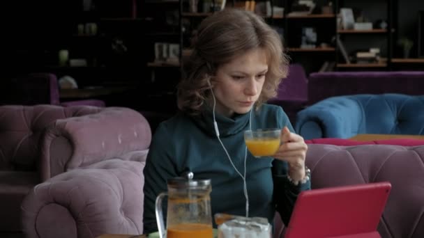 Atractiva joven con tableta en la cafetería, concepto freelancer — Vídeo de stock