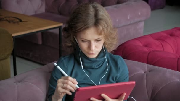 Привлекательная молодая женщина с планшетом в кафе, концепция фрилансера — стоковое видео