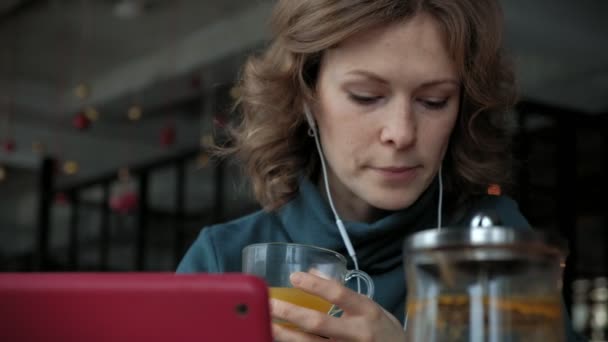 Привлекательная молодая женщина с планшетом в кафе, концепция фрилансера — стоковое видео
