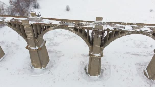 Viejo acueducto ferroviario, puente de piedra. nieve, invierno. aérea, disparo de helicóptero — Vídeos de Stock