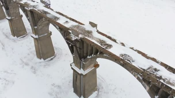 Viejo acueducto ferroviario, puente de piedra. nieve, invierno. aérea, disparo de helicóptero — Vídeos de Stock