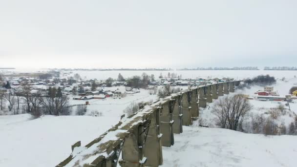Velho aqueduto ferroviário, ponte de pedra. neve, tempo de inverno. aérea, tiro helicóptero — Vídeo de Stock