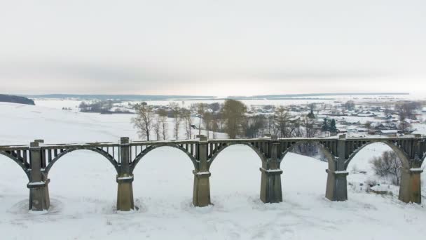 Velho aqueduto ferroviário, ponte de pedra. neve, tempo de inverno. aérea, tiro helicóptero — Vídeo de Stock
