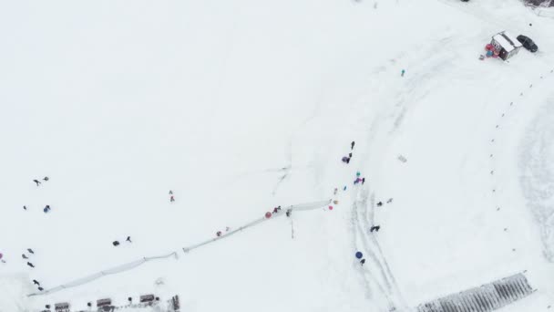 Lykkelige mennesker som morer seg på snøen i vinterparken. luftbesiktelse, helikopterskyting – stockvideo