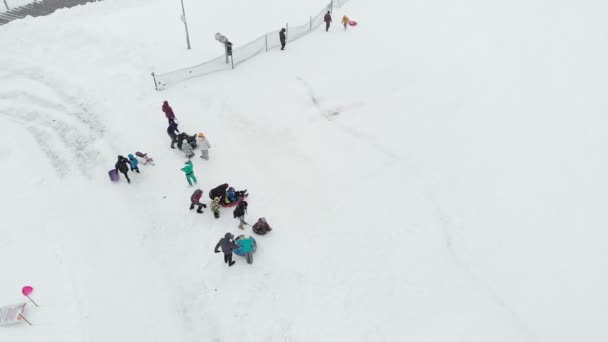 Οι ευτυχισμένοι άνθρωποι διασκεδάζουν στο χιόνι το χειμώνα πάρκο. εναέρια έρευνα, copter σουτ — Αρχείο Βίντεο