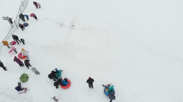 Fröhliche Menschen, die sich im Winterpark auf dem Schnee vergnügen. Luftaufnahme, Hubschrauberabschuss — Stockvideo