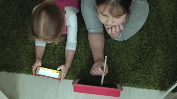 Αδελφές κορίτσια που παίζουν για το tablet στο δωμάτιο, web-surfing, υπόλοιπο — Αρχείο Βίντεο