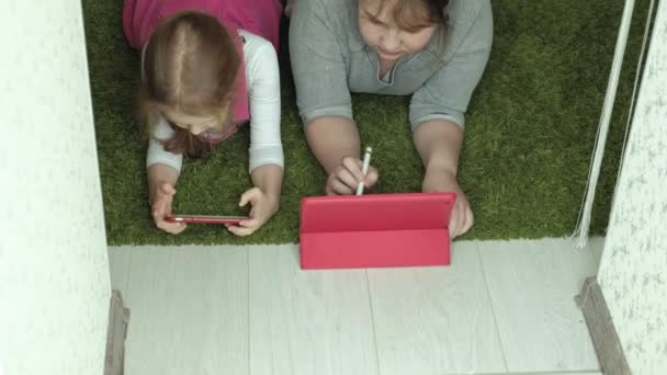 Дівчата сестри грають на планшеті в кімнаті, веб-серфінг, відпочинок — стокове відео