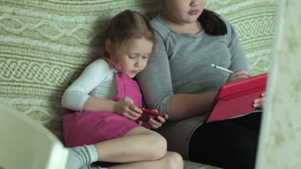 Zusters van de meisjes spelen op de tablet in de kamer, het surfen op het web, de rest — Stockvideo