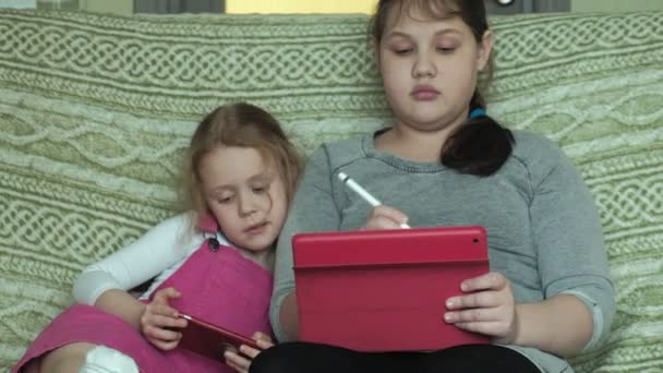 女孩姐妹在房间里的平板电脑上玩, 网上冲浪, 休息 — 图库视频影像