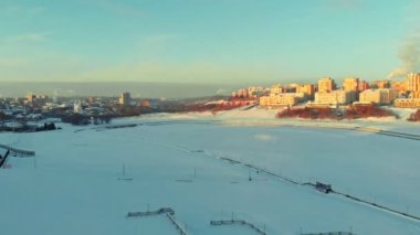 Modern konut şehir içinde donmuş nehrin yanında hava görünümünü. Gün batımı, gündoğumu, havadan çekim, cityscape