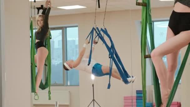 Antenn, antigravity yoga i gymmet. Grupp människor svänga i hängmattorna — Stockvideo